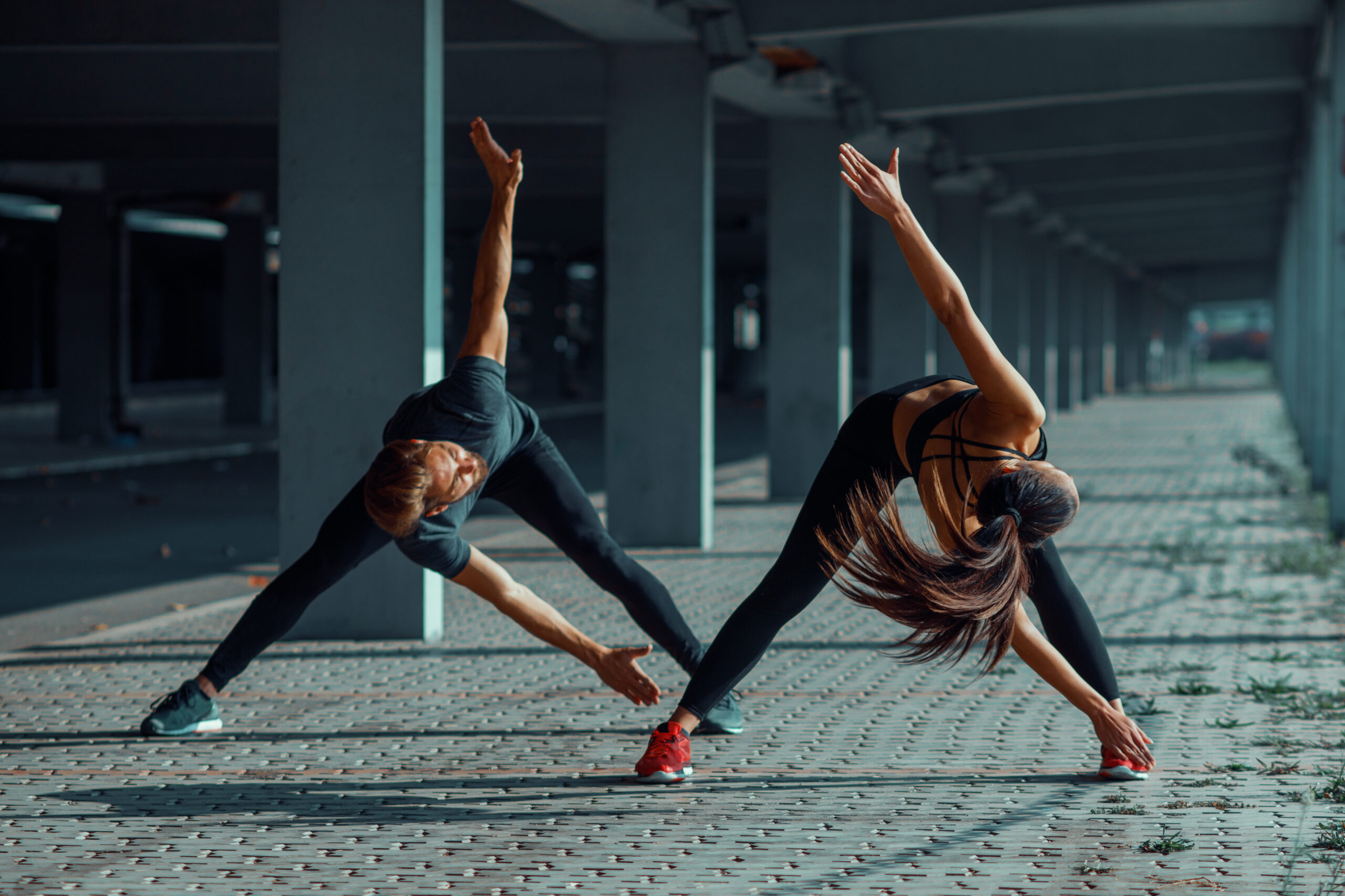 Young couple warming up in an urban environment before jogging